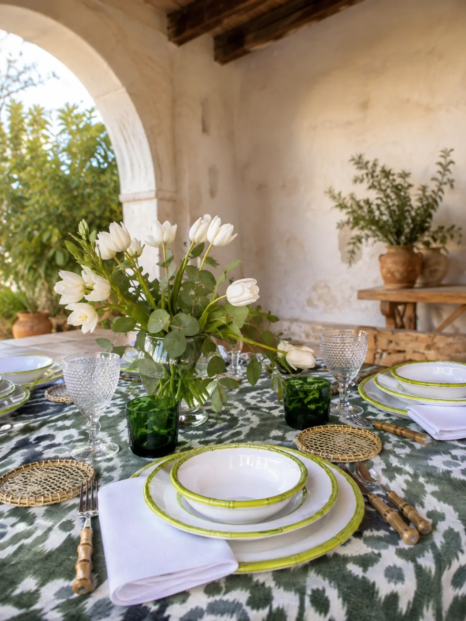 Vajilla de loza Bambú Verde: mesa de terraza montada sobre mantel de ikat